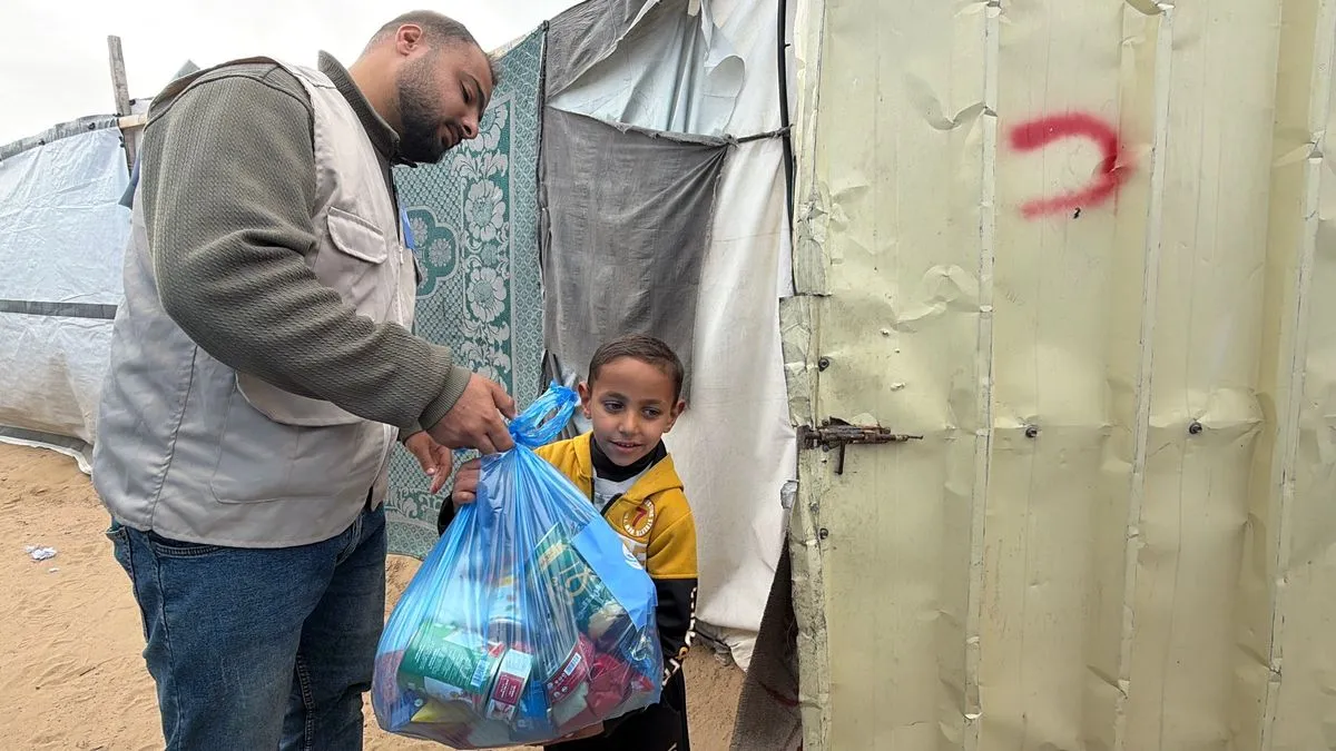 An SDQA food pack handed to a child during a distribution